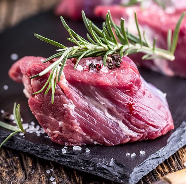 Raw beef meat. Raw beef tenderloin steak on a cutting board with rosemary pepper salt in other positions.